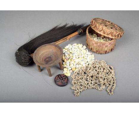 An Oceanic fibre woven basket and cover, 14cm diameter containing a quantity cowrie and other shells, a hair fly whisk mounte