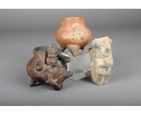 A pre-Columbian pottery vessel, with a figure having a plumed headdress, on three legs, 9cm high, a pottery tripod vessel wit