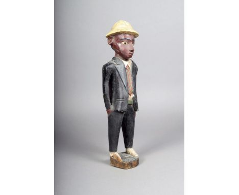 A Nigerian Colon male figure, standing and wearing suit and tie with a pith helmet, 44.5cm high.