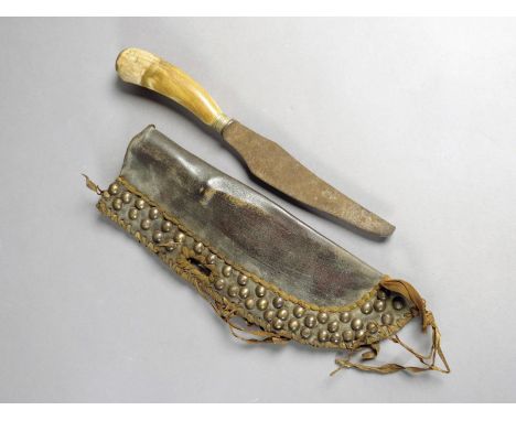 A North American Indian scalping knife and scabbard, probably Blackfoot tribe, with a steel blade and horn handle, 29cm long,