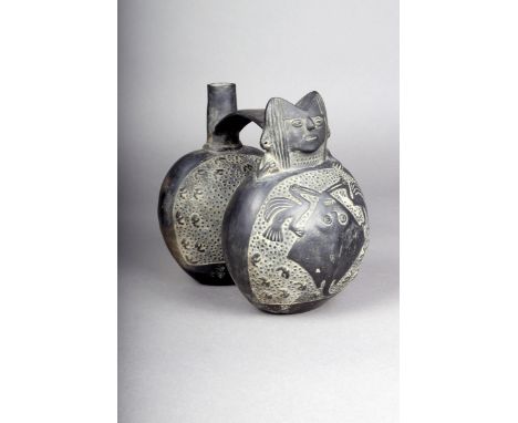 A Chimu / Inca double vessel, relief decorated stingrays and birds, with head and spout terminals linked with an arched handl