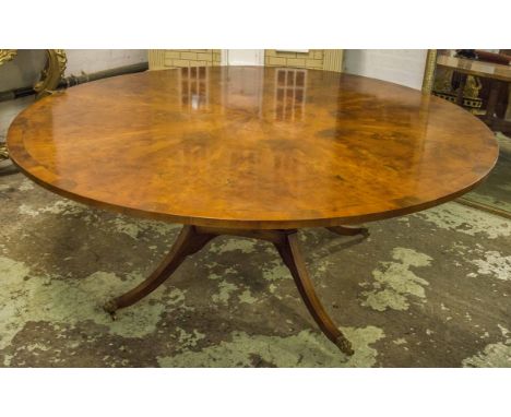 DINING TABLE, burr yewwood with a circular top on fluted column supports with swept lion paw headed feet and castors, 183cm d