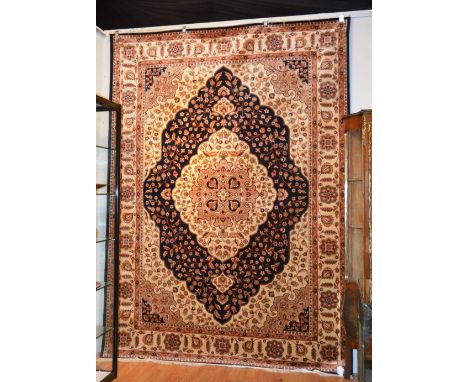 A Kum motif carpet/wall hanging, with central floral gold medallion over blue ground, spandrels and floral borders, 280 x 200