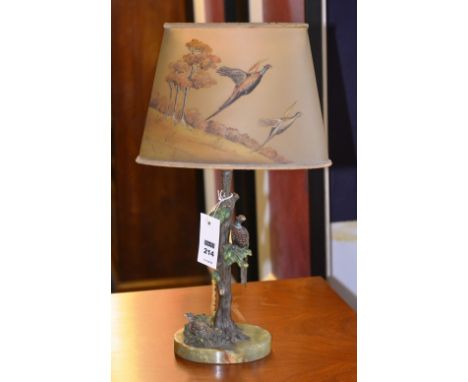 A cold painted bronze table lamp, decorated with game birds on tree branch, raised on oval onyx base, with game bird decorate