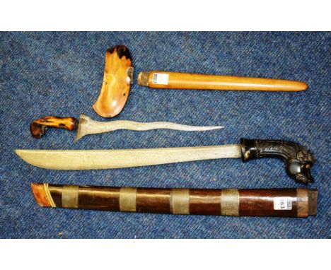 A Celanese sword (Kastane), with mythical beast carved wood handle, tapering iron blade and bamboo and horn scabbard, includi