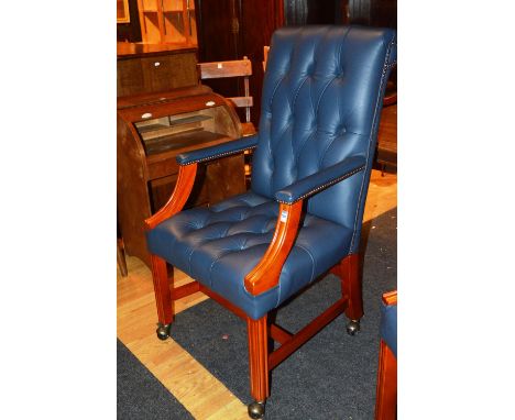 A modern blue hide desk chair, with button back decoration, raised on plain supports and castors, 107cm high x 60cm wide