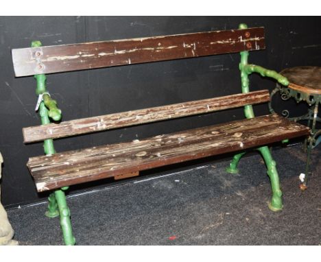 A Victorian green painted cast iron garden bench, with slatted plank wood back rest and seat