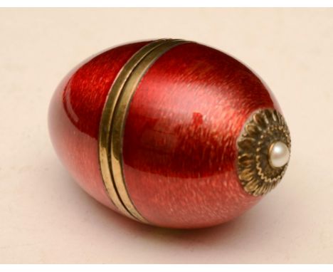 A silver gilt and red enamel musical egg, in the style of Faberge, hallmarks for London, 58/200, 9cm diameter