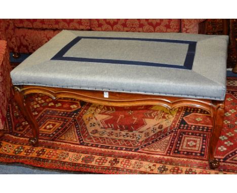 A mahogany centre stool, of rectangular form, upholstered in blue fabric, raised on cabriole supports and scroll feet, 51cm h
