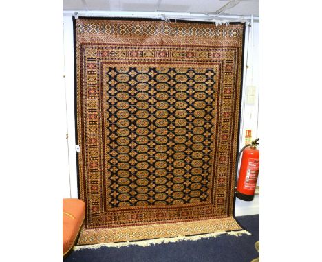 A Bokhara motif carpet/wall hanging, with five rows of 17 guls, over blue ground and geometric border, 230 x 160cm
