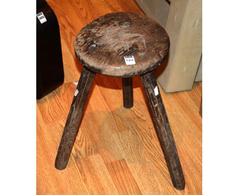 A vintage wooden milking stool, raised on tripod supports, 43cm high x 26cm wide