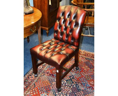 An ox blood hide button back desk chair, raised on plain supports with under stretchers, 90cm high x 48cm wide