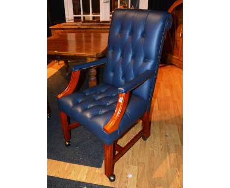 A modern blue hide desk chair, with button back decoration, raised on plain supports and castors, 107cm high x 60cm wide