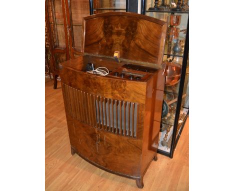 A vintage walnut radiogram, the hinged lid enclosing turntable above speaker grill, 98cm high x 75cm wide x 39cm deep CONDITI