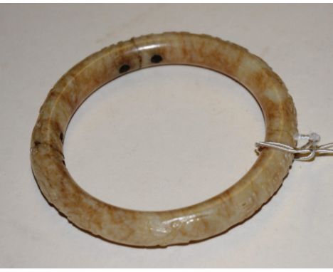 A Chinese hardstone bangle, of circular form, decorated with symbols and markings, 6cm diameter (a/f)