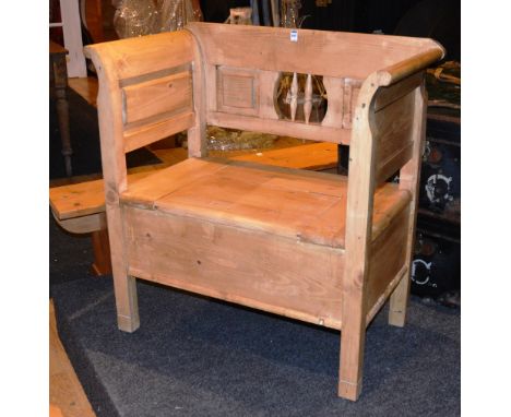 A stripped wood hall bench, modelled as a settle, with hinged seat, raised on block supports, 92cm high x 81cm wide x 59cm de