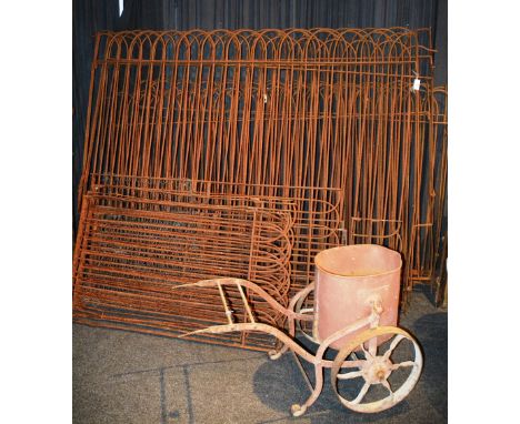 A quantity of vintage cast iron railing and fence fittings, various sizes, together with a wheel barrow and pail (a lot)