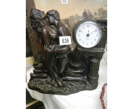 A figural mantel clock in a bronzed finish.Dimensions are H29cm x L28cm x W13cmWeight is just under 3.5 kilos
