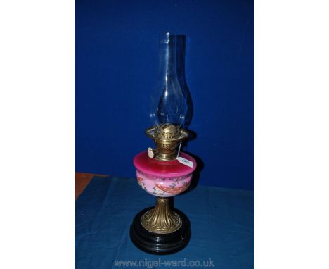 A Victorian Oil Lamp with brass base and pink hand painted glass reservoir with original chimney
