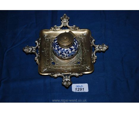 An embossed brass and ceramic Inkwell