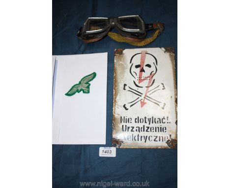 A German Luftwaffe eagle patch, a pair of vintage motorcycle glasses and a Polish electrocution sign