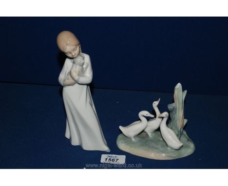 A Nao figure of three ducks and a Nao figure of a girl with a puppy