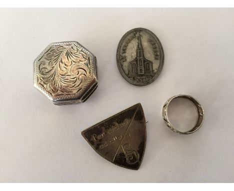 An Elizabeth II silver pill box, together with a school badge a church token and a white metal ring