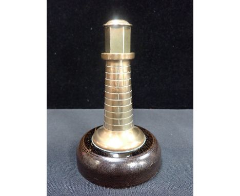 A VINTAGE TABLE CIGARETTE LIGHTER in brass, of lighthouse form 14.5cm high