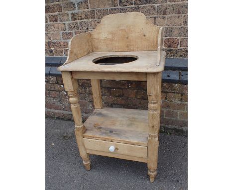 A VICTORIAN STRIPPED PINE WASHSTAND with basin hole and shaped back, on turned front legs with drawer below 54cm wide