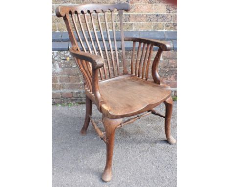 A LATE 19TH CENTURY OAK ARMCHAIR, WITH SHAPED SOLID SEAT and cabriole front legs, shaped comb back, and scrolling arms, label