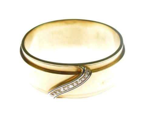 Victorian diamond set gold hinged bangle, unmarked, the central line of twelve old brilliant cuts between a dark blue enamel 