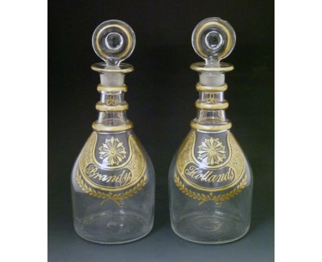 Pair of 19th Century clear glass decanters of tapered form, each having a circular lozenge stopper, three rings to the neck a
