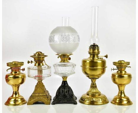A pair of brass oil lamps, with an Art Deco gilt metal oil lamp, a larger brass oil lamp and a cast iron oil lamp with opaque