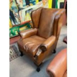 A good quality reproduction brown leather wingback elbow chair on cabriole supports.