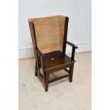 A reproduction stained pine Orkney chair, with shaped arms and rush weave back, height 84cm, width
