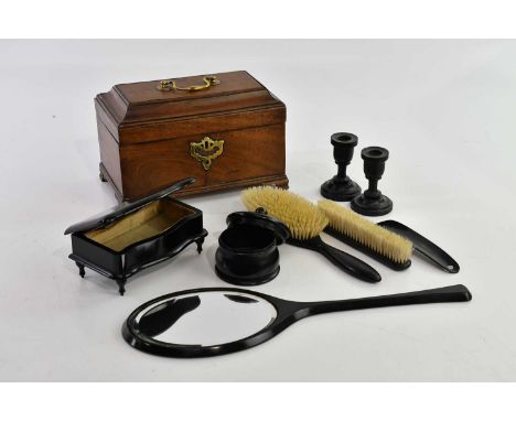 A George III mahogany tea caddy (lacking interior), length 24cm, and an ebonised dressing table set (2).