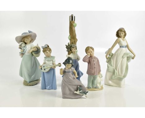 NAO; five figures and a table lamp including a girl holding a doll and basket, height 24cm, boy beside teddy bear, etc (6)   