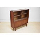 BEAVER & TAPLEY LTD; a mid century teak bookcase with a pair of glass sliding doors above a pair