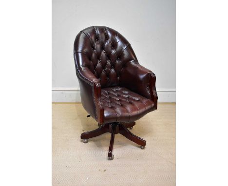 A good reproduction brown leather swivel office chair, upholstered in a button back material.