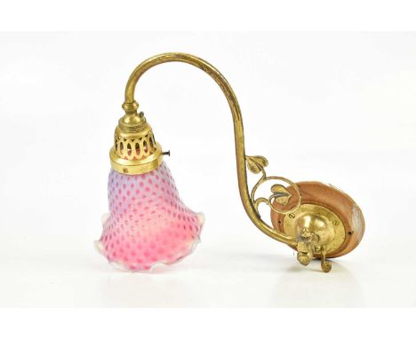 An Art Nouveau brass wall light with rotating arm and applied floral decoration and cranberry and vaseline glass shade.