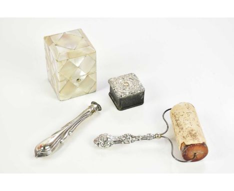 A white metal topped inkwell in a mother of pearl box, with a white metal mounted stamp box, a white metal handled roller and