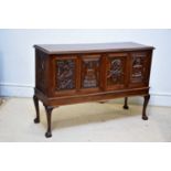 A mahogany cabinet, the four doors carved with Oriental scenes, on cabriole legs, height 98cm, width