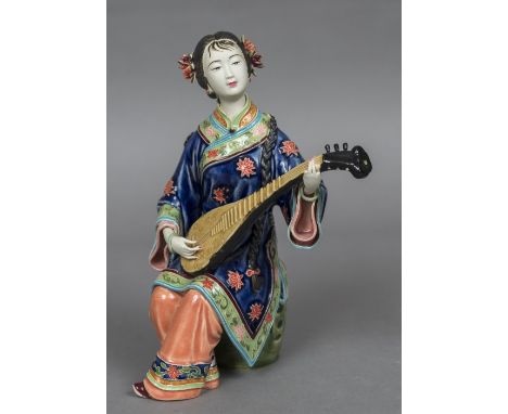 A Chinese porcelain figureModelled as a young lady playing a pipa, impressed seal mark inscribed and numbered 33 to base.  25