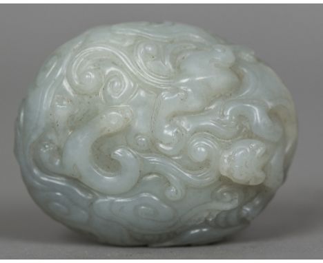 A Chinese carved white jade pebbleWorked with mythical beasts and stylised clouds.  6.5 cm wide. CONDITION REPORTS: Generally