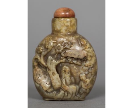 A Chinese carved russet jade snuff bottle and stopperCarved with figures beneath a tree, the stopper probably coral.  6.5 cm 