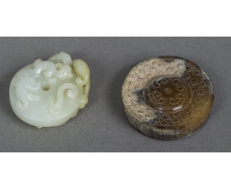 A Chinese carved pale jade roundelWorked with mythical beasts and pierced; together with another worked with scrolls.  The fo