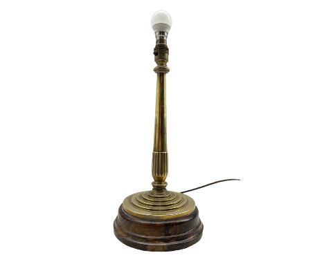 Early 20th century brass lamp, the tapered stem supported by a circular stepped base, raised on lignum vitae turned plinth, H