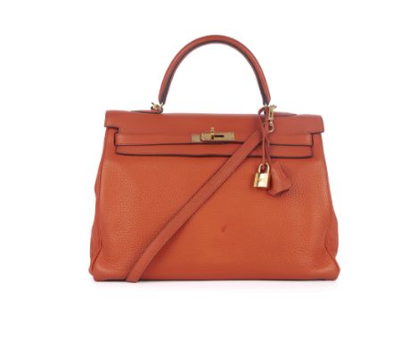 Hermes, a 2015 Kelly Retourne 35 handbag, crafted from coral orange Clemence leather, featuring a structured top handle and a