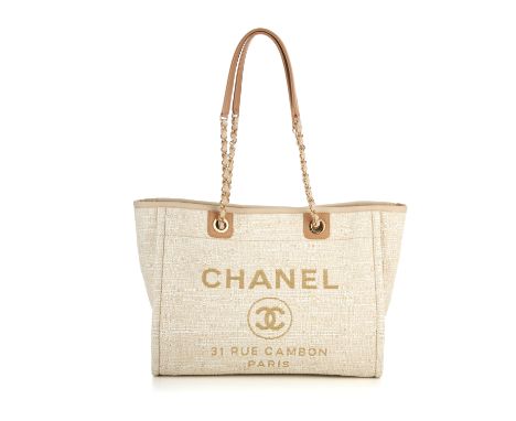 Chanel, a Deauville tote handbag, designed with a cream tweed canvas exterior with beige leather trim, featuring the maker's 