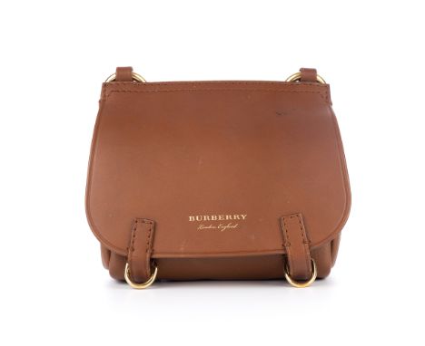 Burberry, a small crossbody saddle bag, crafted from tan leather with bushed gold-tone hardware accents, a thin adjustable cr